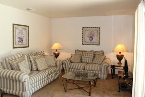 A living room with two striped couches and a coffee table.