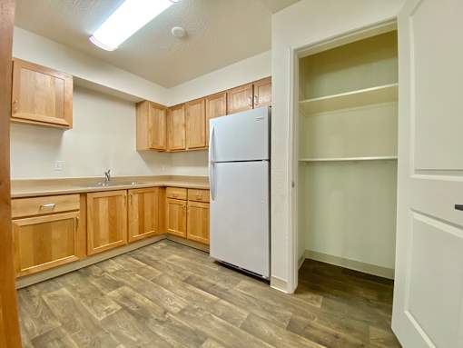 A kitchen with wooden cabinets and a white refrigerator.
