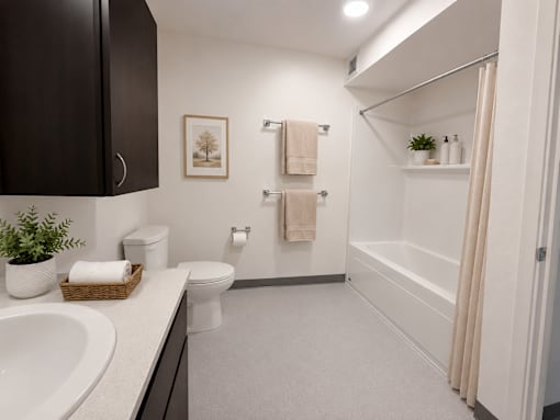 A bathroom with a toilet, sink, and a plant.
