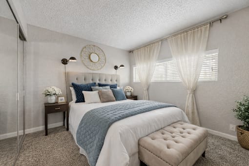 A bedroom with a bed, nightstand, and window. at Infinity on the Landing Apartments , Apartments, Euless, TX
