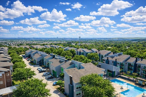 A view of a residential area with houses and a swimming pool. at Infinity on the Landing Apartments , Euless, Texas