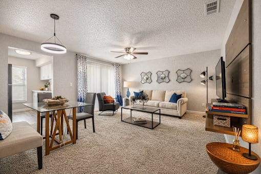 A living room with a couch, chairs, and a coffee table. at Infinity on the Landing Apartments , Euless