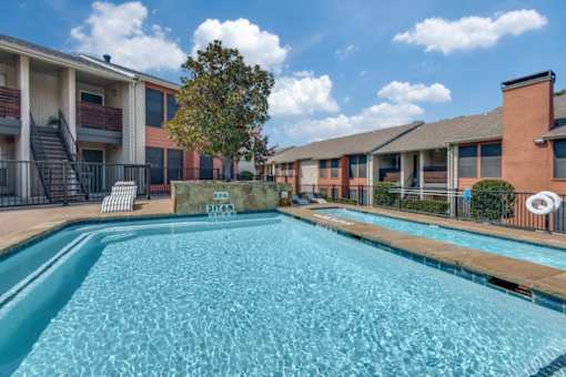 A swimming pool in front of apartment buildings at Infinity on the Oaks Apartments , Dallas, TX, 75231