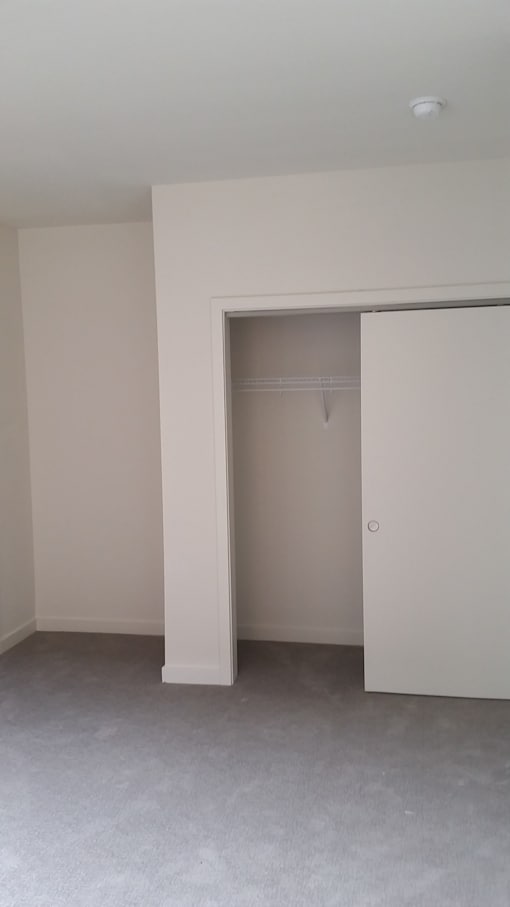 A white door is open in a white room.
