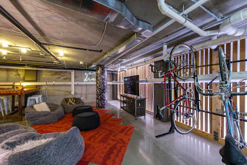 A room with a bicycle hanging on the wall and bean bag chairs on the floor.