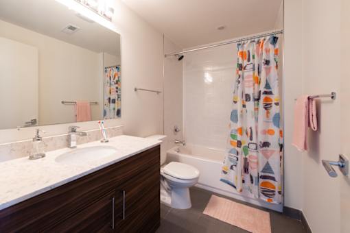 A bathroom with a toilet, sink, and shower curtain.