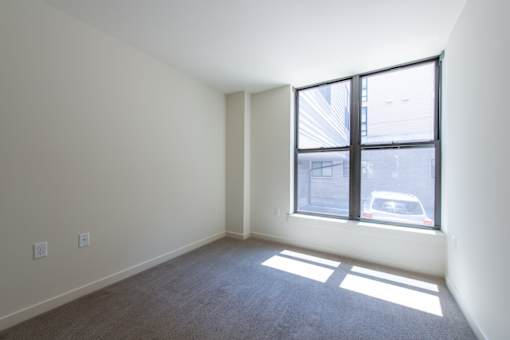 A room with a large window and a car outside.