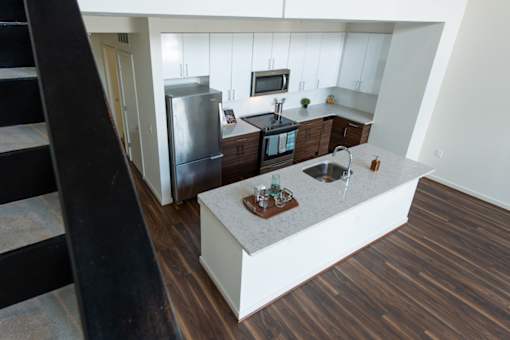A kitchen with a refrigerator, microwave, and oven.