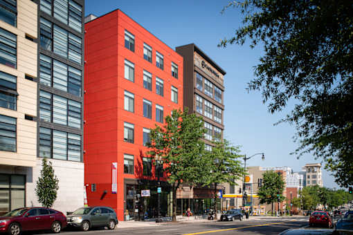 A red building with a tree in front of it.