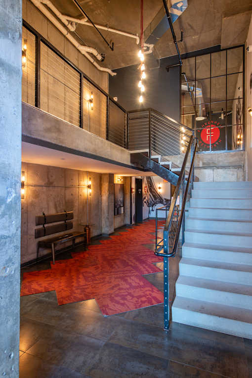 A staircase with a metal railing and a red carpet.