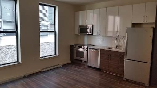 A kitchen with a refrigerator, microwave, and dishwasher.