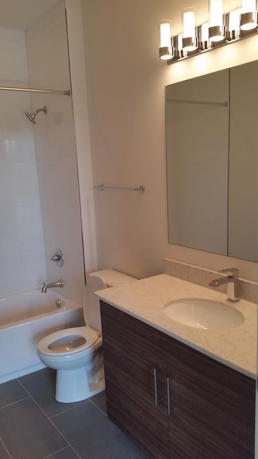 A white toilet sits in a bathroom next to a sink.