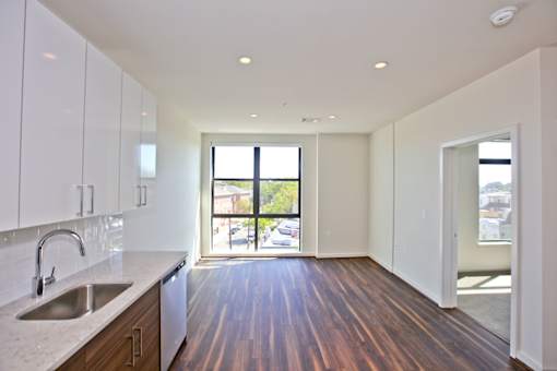 A kitchen with white cabinets and a sink.