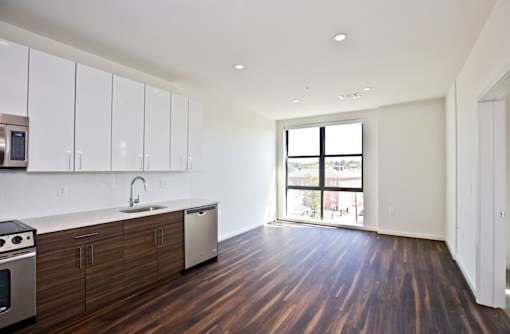 A kitchen with wooden floors and white cabinets.