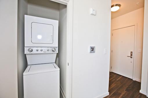A white washing machine is built into a wall in a room.