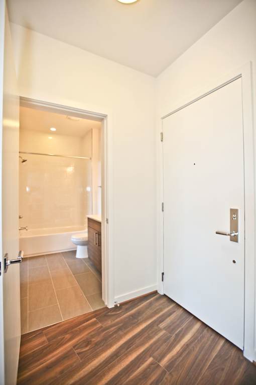 A white door is closed in a room with wooden floors.