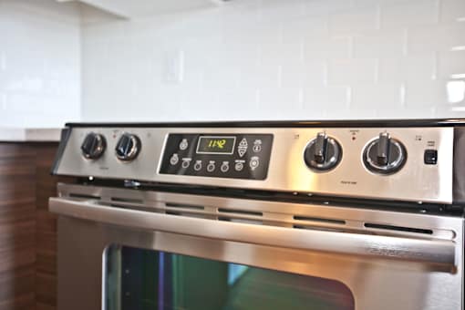 A stainless steel oven with a digital display and control panel.