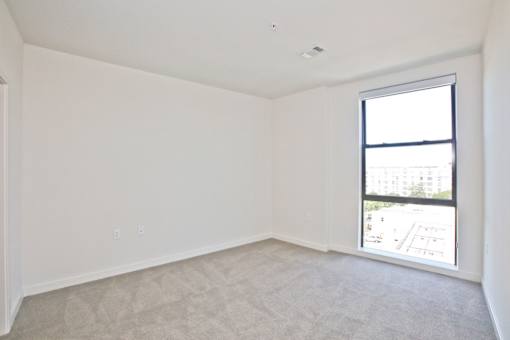 A room with a window and carpeted floor.