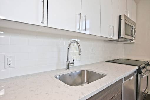 A kitchen with a sink and a microwave.