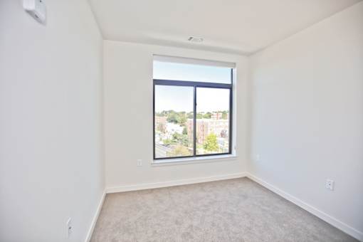 A room with a window and a view of a cityscape.