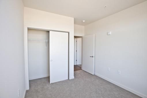 A white room with a carpet floor and a white door.