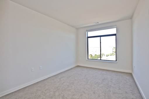 A room with a window and carpeted floor.