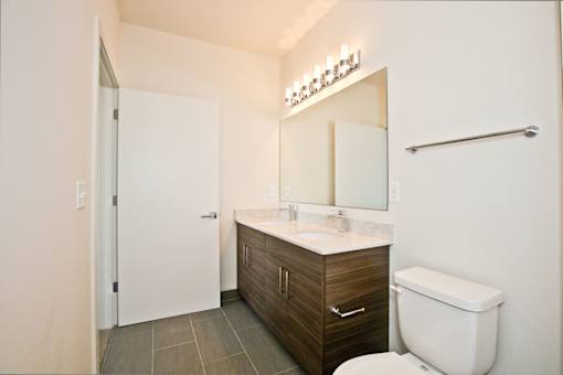 A bathroom with a white toilet, a sink, and a mirror.