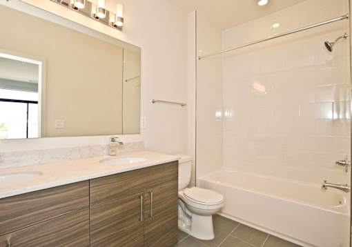 A white bathroom with a toilet, sink, and tub.
