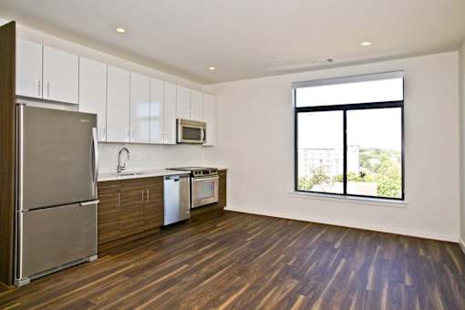 A kitchen with a refrigerator, microwave, oven, and dishwasher.