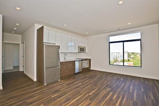 A kitchen with wooden floors and a refrigerator.