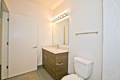A white toilet sits next to a sink in a bathroom.