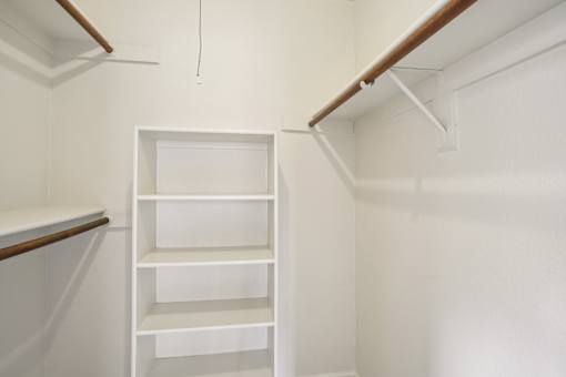 A white shelving unit in a room with white walls.