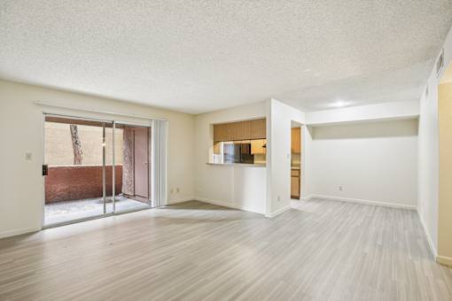 A room with a sliding glass door leading to a balcony.
