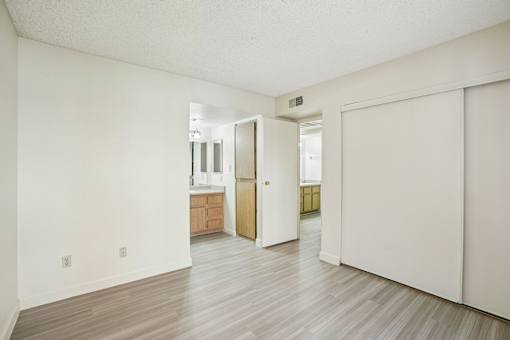 A room with a white wall and a wooden floor.