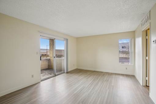 A room with a sliding glass door leading to a balcony.