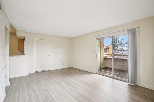A room with a sliding glass door leading to a balcony.