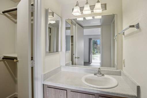 A bathroom with a sink, mirror, and light fixture.
