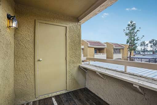 A beige door is on the left side of a balcony.