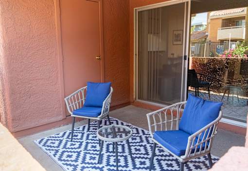 Two chairs and a table are on a patterned rug.