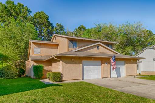 A house with a garage and an American flag hanging on it.