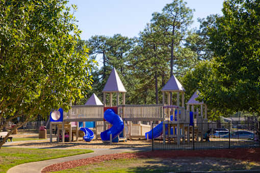 A playground with a blue slide and two towers.