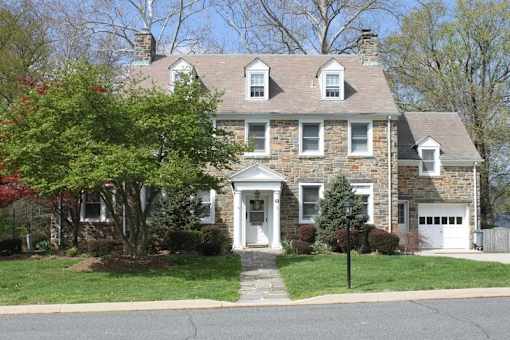 A two-story house with a white door and windows.