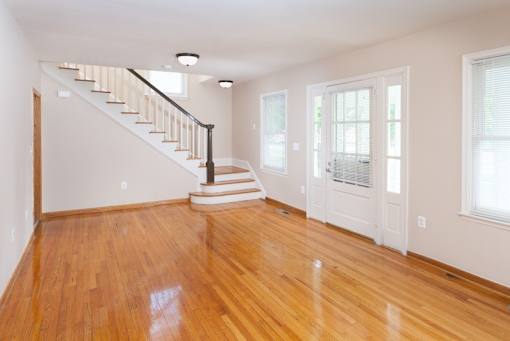 A room with wooden floors and a staircase.