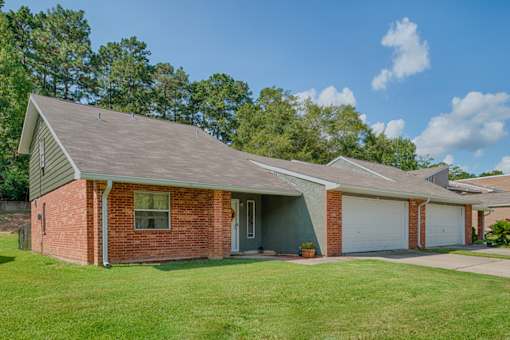 A house with a grey roof and a brick wall.