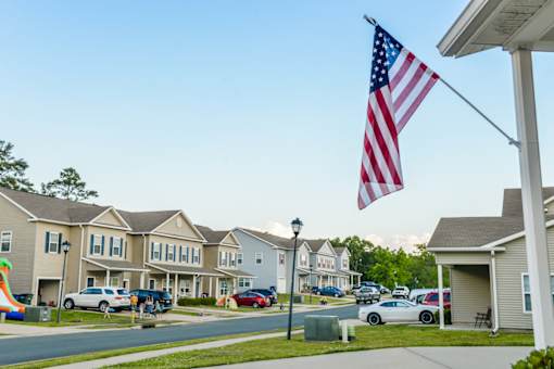 A row of houses with an American flag in front.