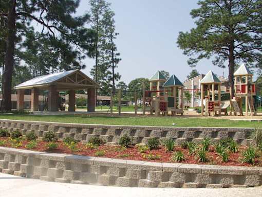 A playground with a wooden structure and a green roof.