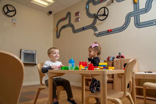 Two children playing with toys in a playroom.