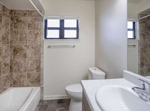 A bathroom with a toilet, sink, and tub.