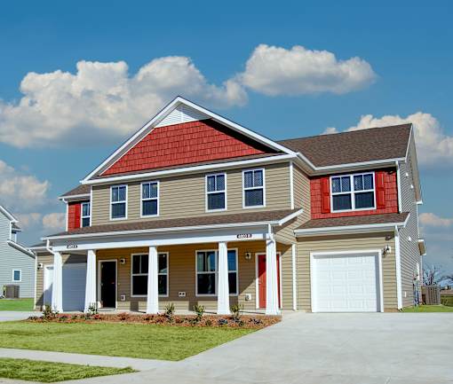 A two-story house with a red roof and a garage.