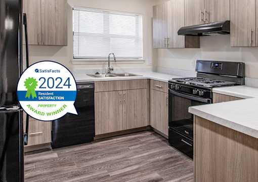 A kitchen with a black fridge and a stove top oven.